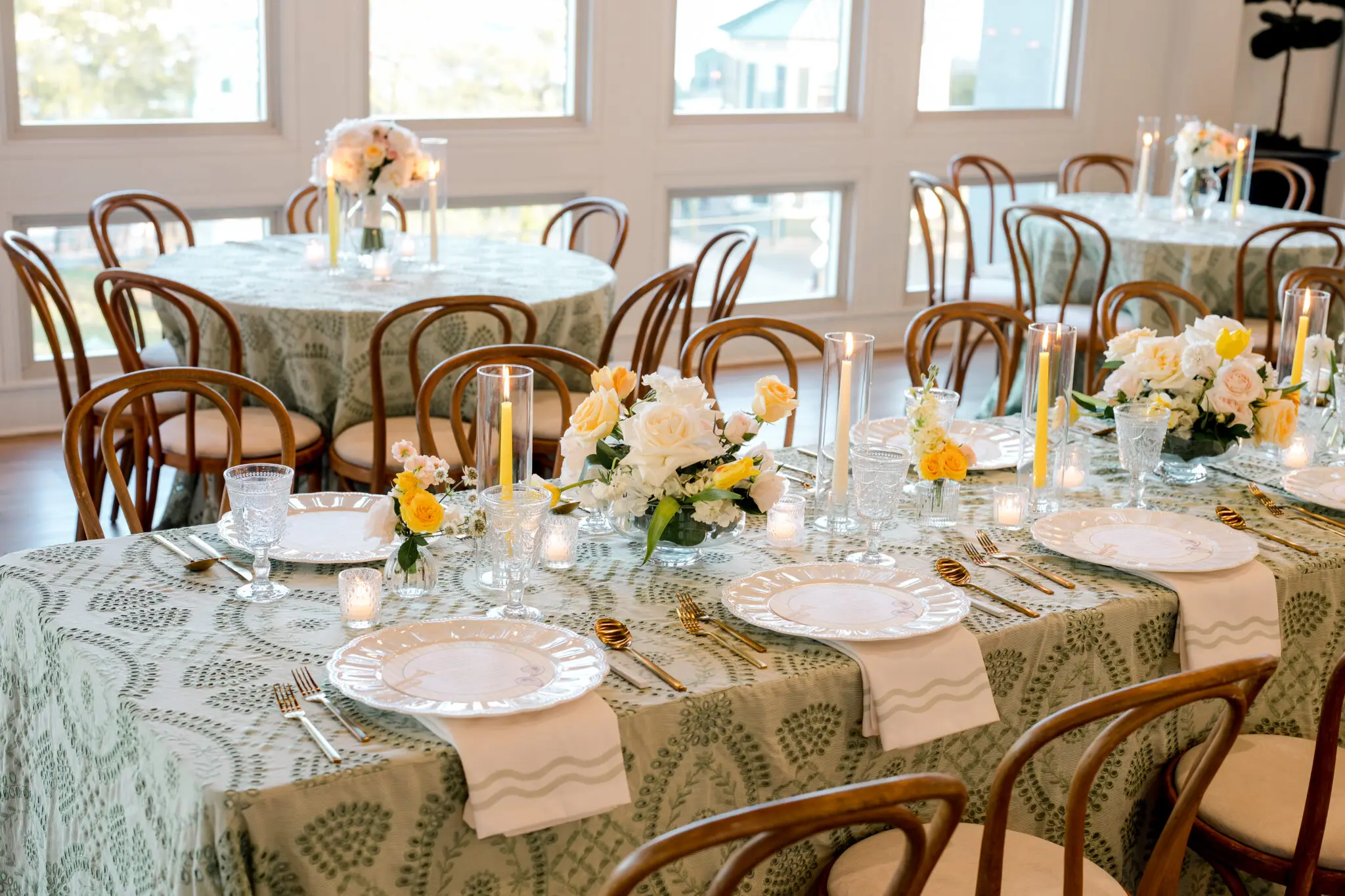 Elegant wedding reception table setting at The MISI by Messina’s in New Orleans with floral centerpieces, candles, patterned linens, and gold place settings.