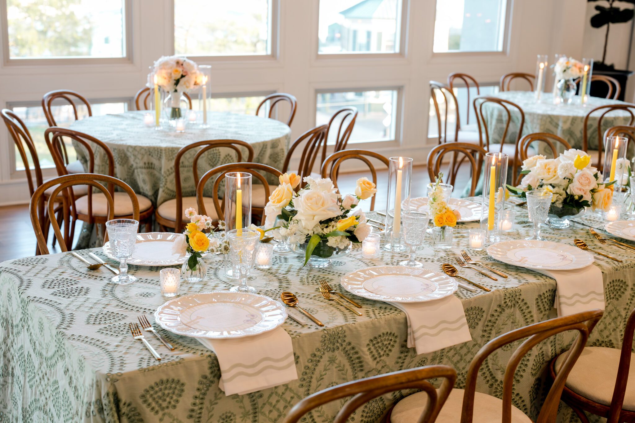 Elegant wedding reception table setting at The MISI by Messina’s in New Orleans with floral centerpieces, candles, patterned linens, and gold place settings.